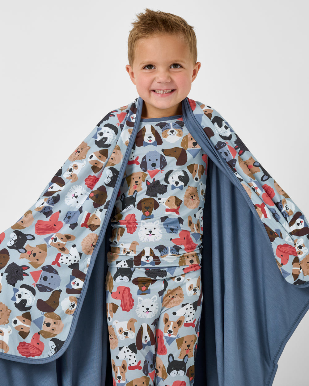 Close up of boy wrapped in the Gray Puppy Parade Large Cloud Blanket®