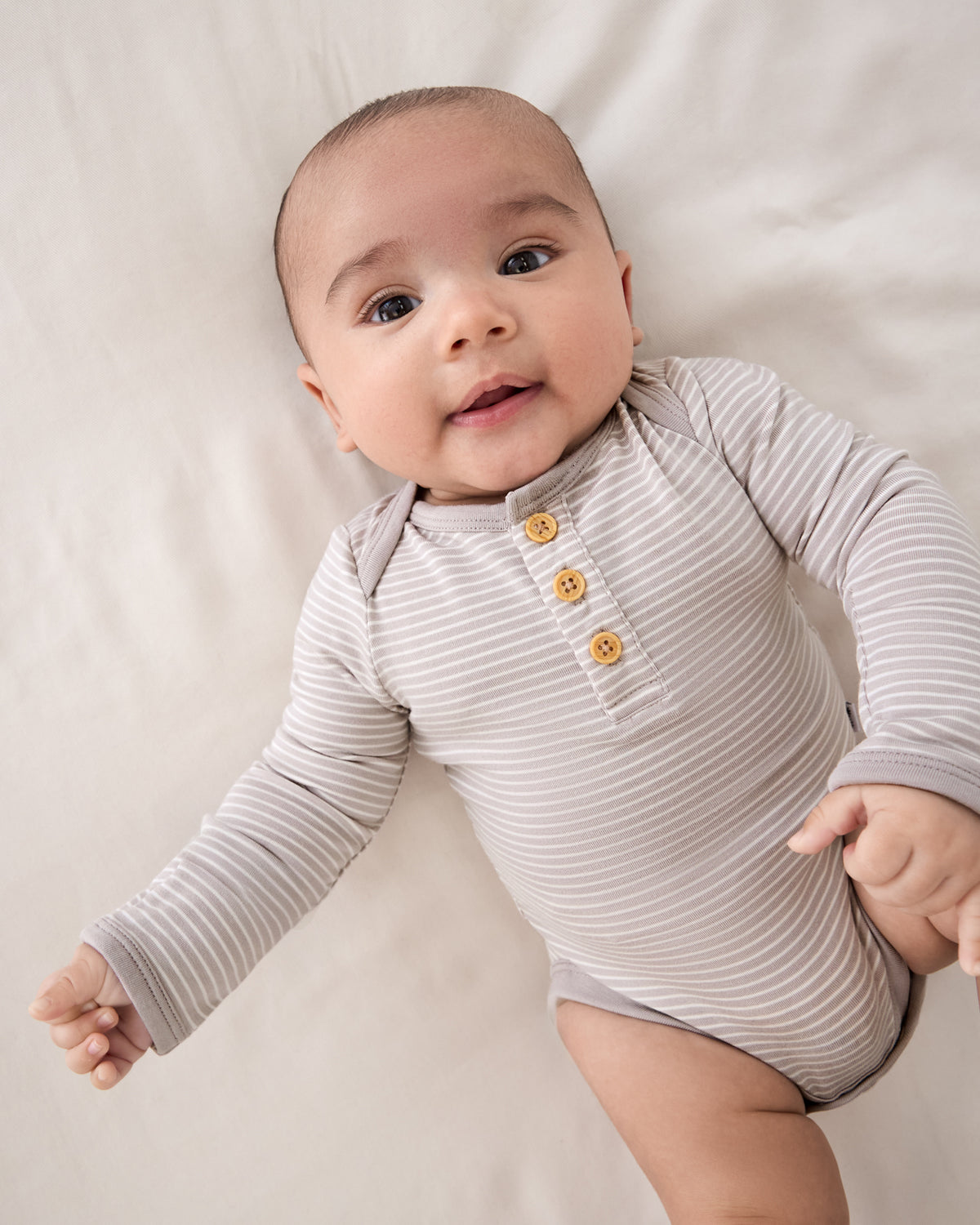 Close up of newborn wearing the Dove Gray Stripe Henley Bodysuit