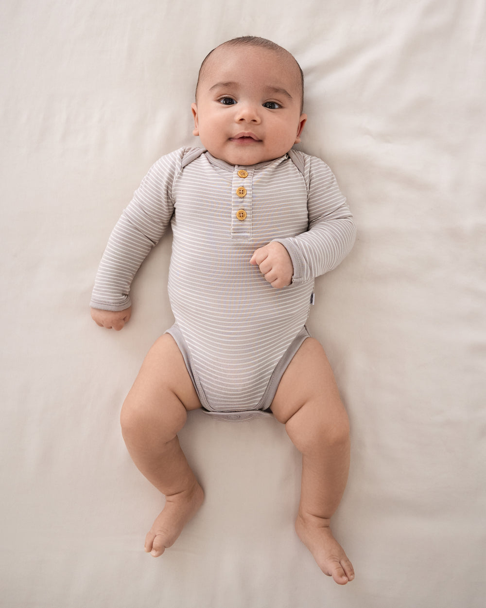 Overhead view of baby wearing the Dove Gray Stripe Henley Bodysuit