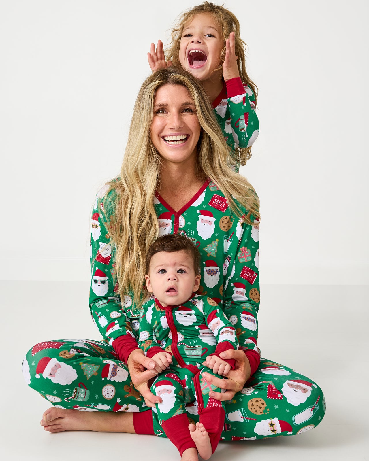Mother and two children wearing matching Cookies for Santa holiday pajamas