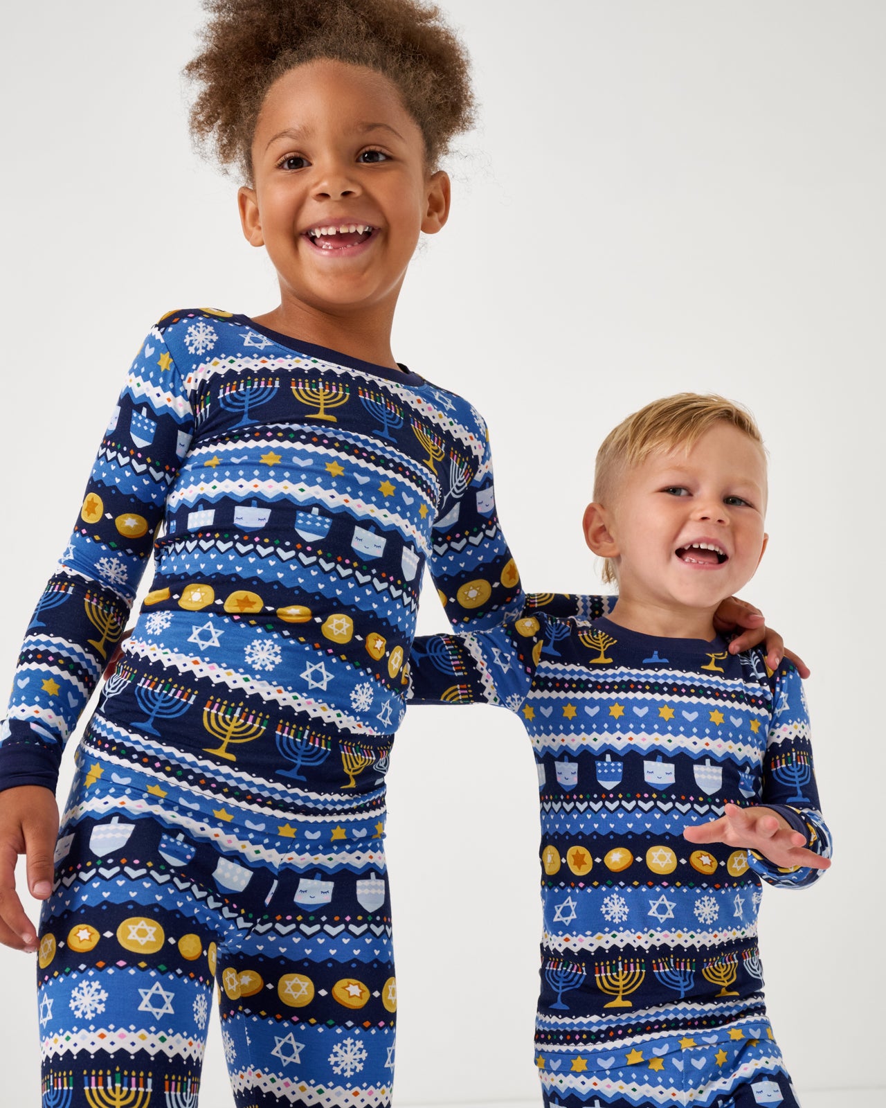 Close up of two children wearing the Hanukkah Fair Isle Two-Piece Pajama Set