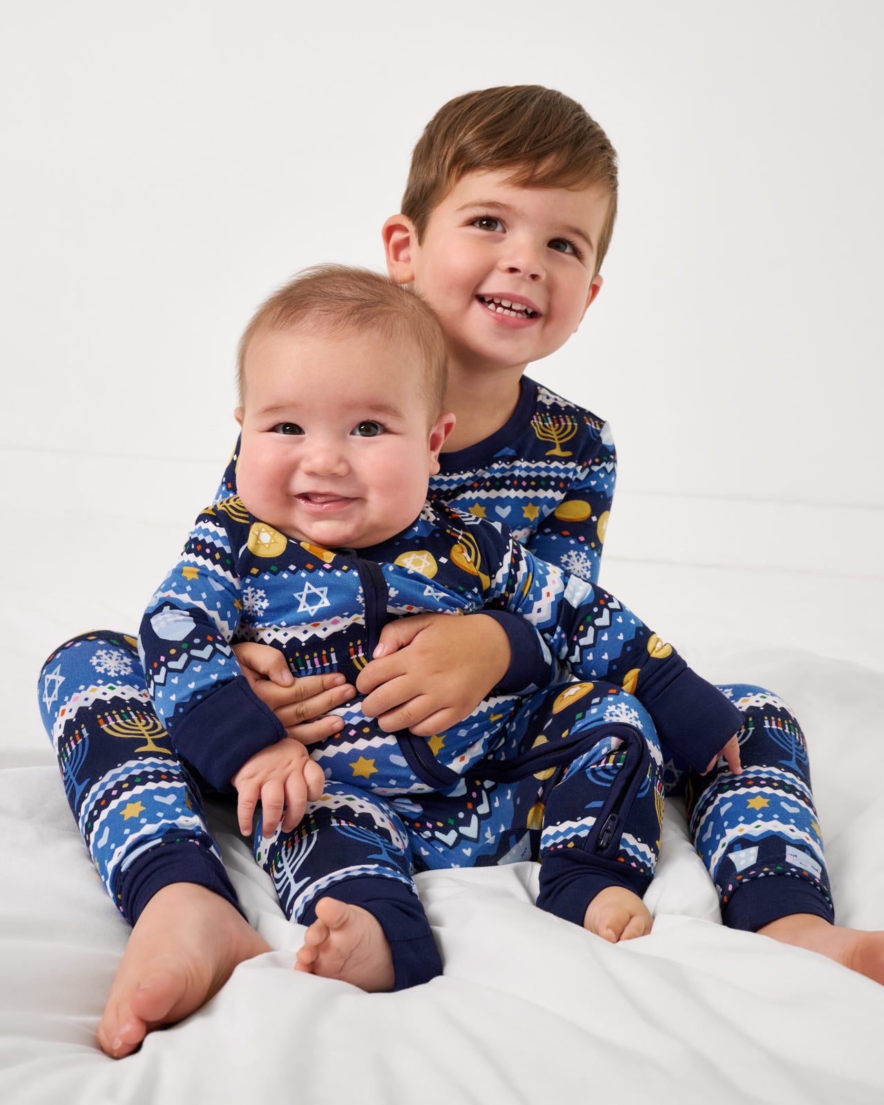 Two children wearing matching Hanukkah Fair Isle bamboo pajamas