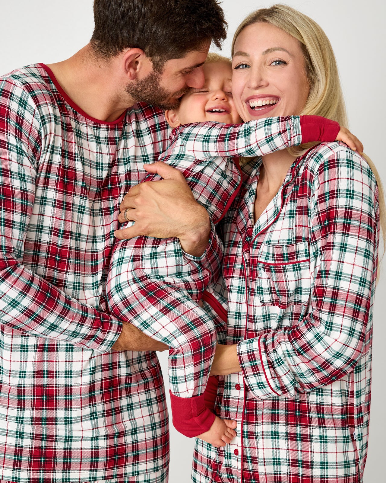 Family of three wearing matching Holly Plaid Christmas pajamas