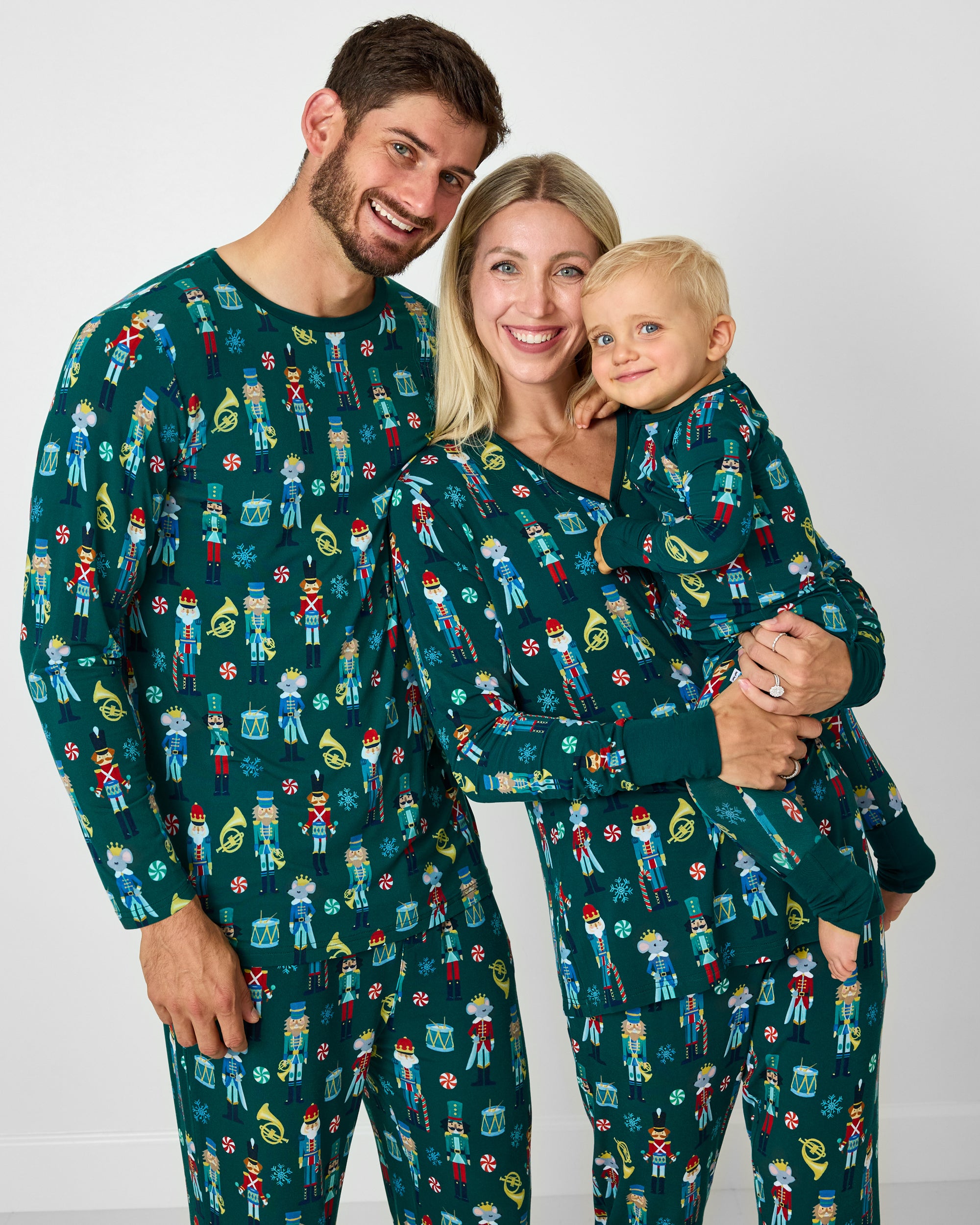 Family of three wearing matching Nutcracker March holiday pajamas
