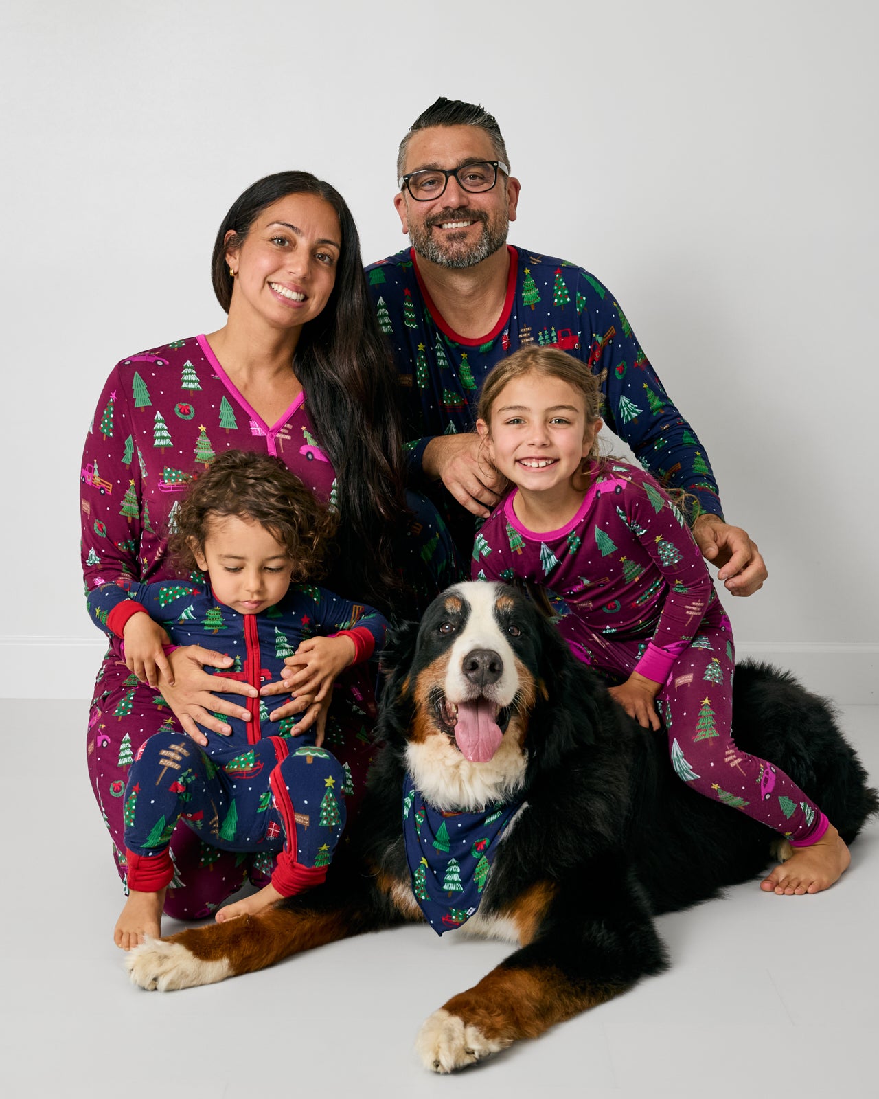 Family of four and their dog wearing matching Tree Traffic holiday themed pajamas