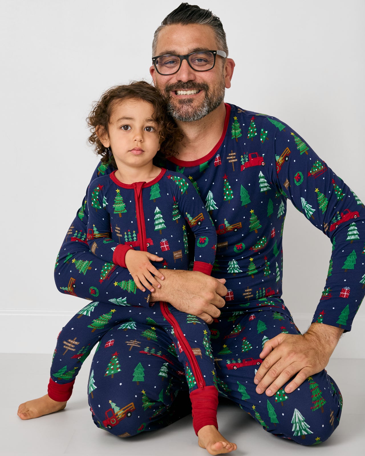 Father and child wearing matching Navy Tree Traffic pajamas