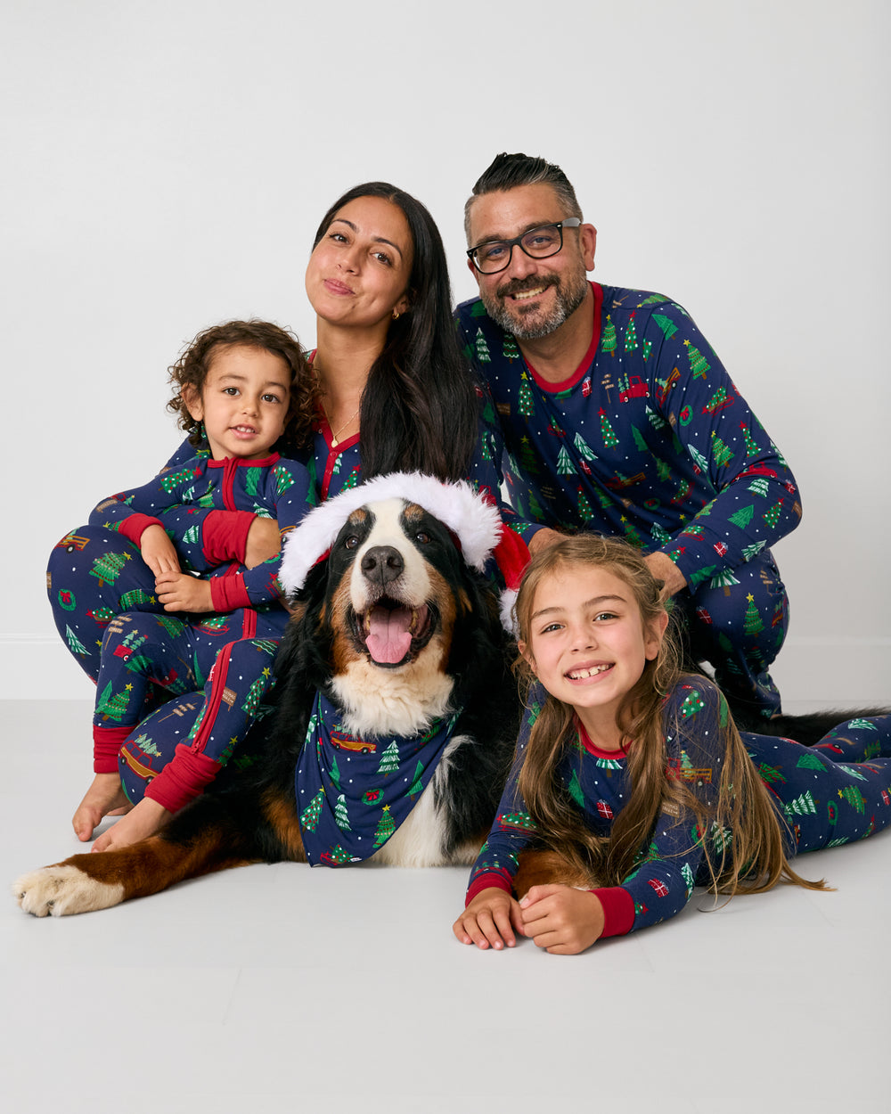Family of four and their dog wearing matching Navy Tree Traffic holiday pajamas
