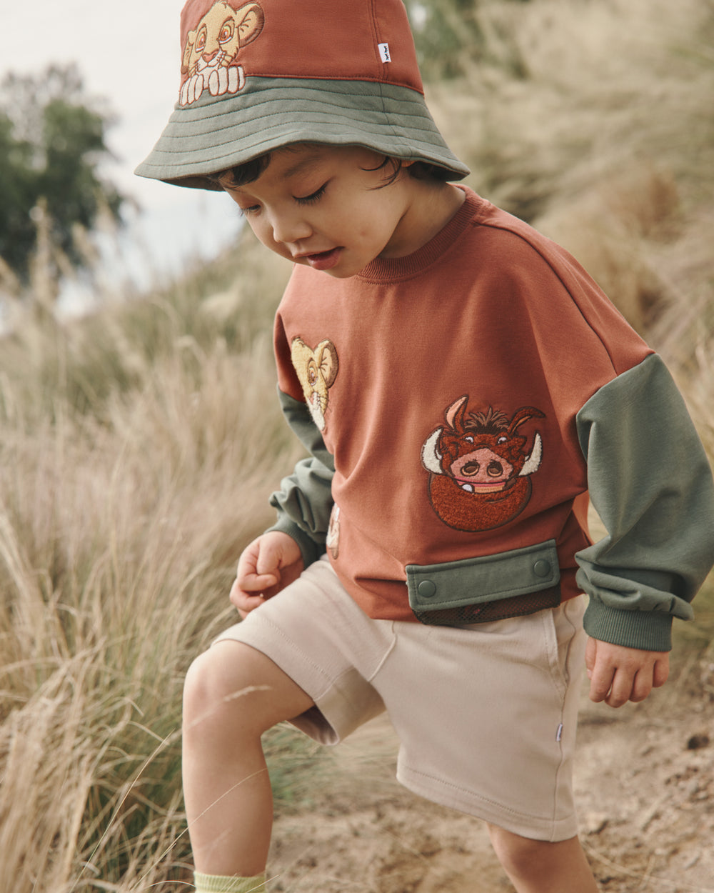 Boy wearing the Disney Simba Bucket Hat with a grassy background