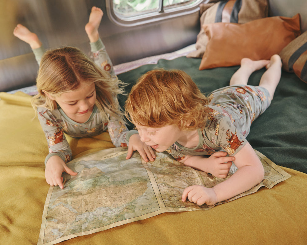 Two children reading a map wearing Disney Simba's Safari Two-Piece Pajama Sets