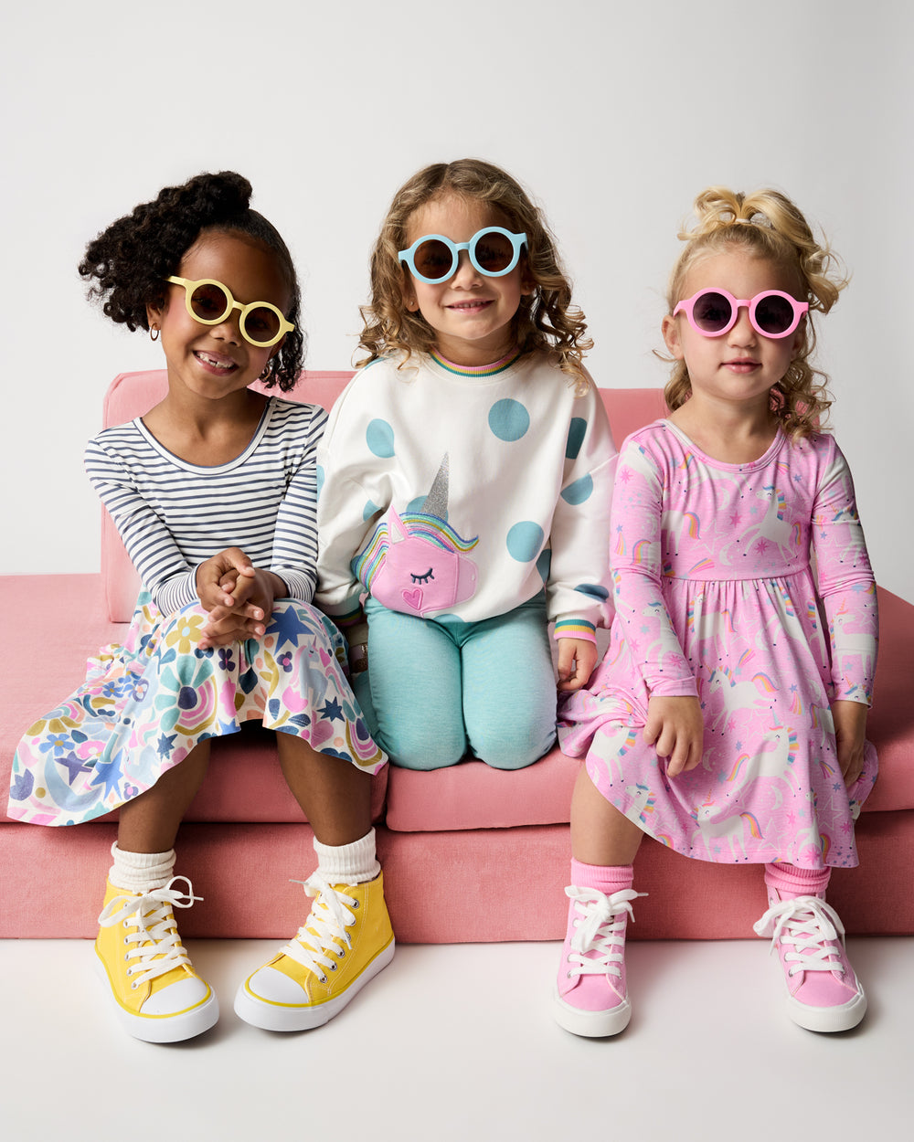 Three girls wearing styles from the Winter Play collection with round sunglasses