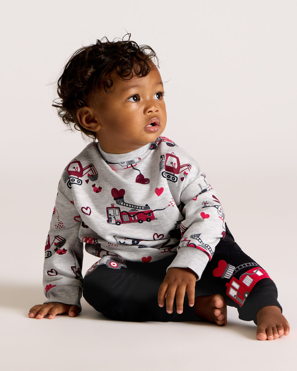 Sitting boy wearing the Loads of Love Easy Crewneck Sweatshirt