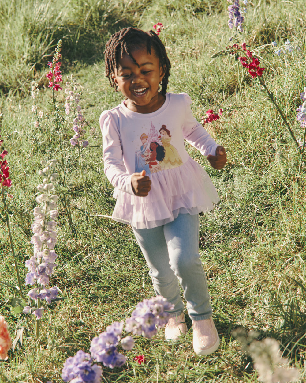 Girl in a grassy field wearing the Disney Castle Daydream Peplum Top
