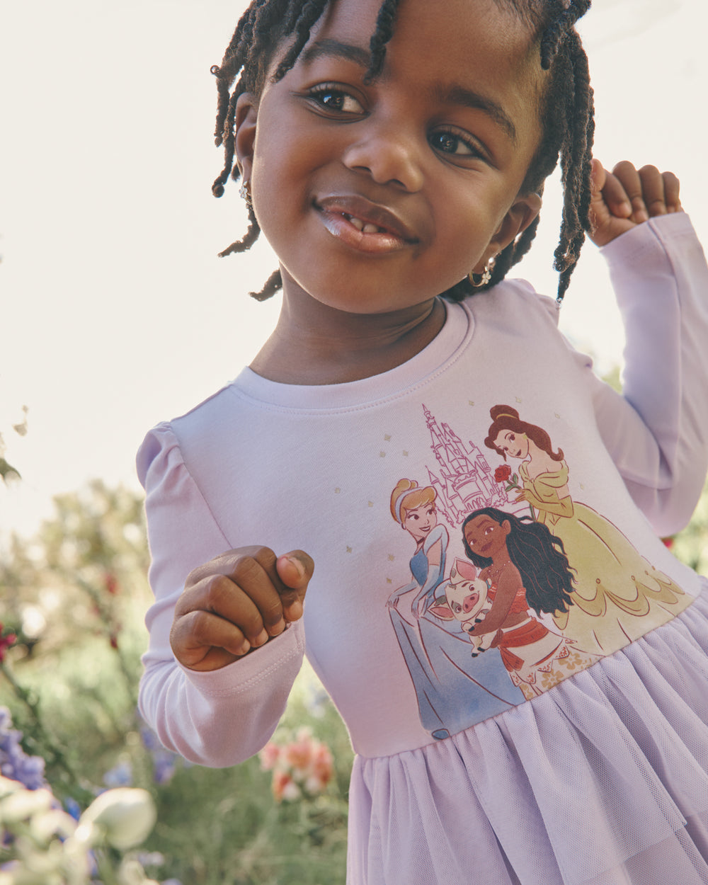 Girl wearing the Disney Castle Daydream Peplum Top with a grass background