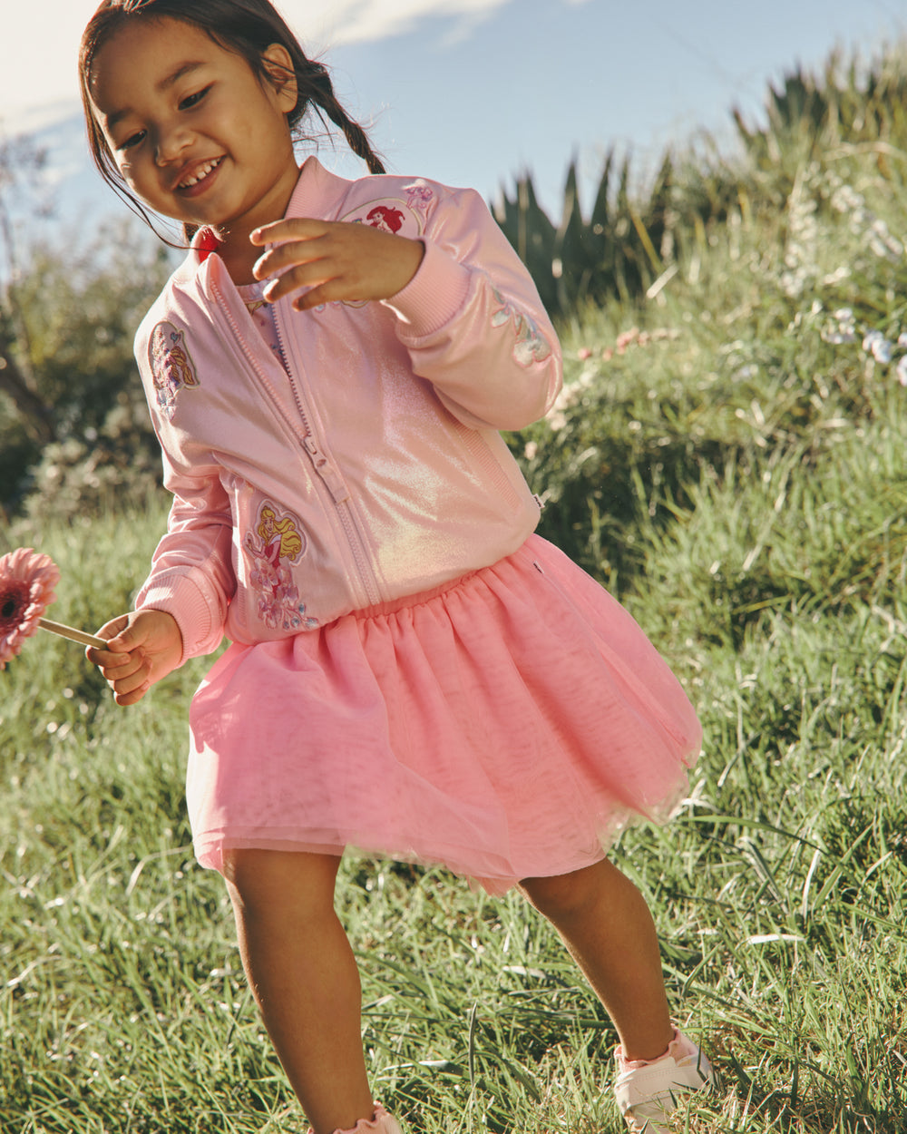 Girl wearing the Disney Princess Iridescent Varsity Jacket with a pink tutu shirt