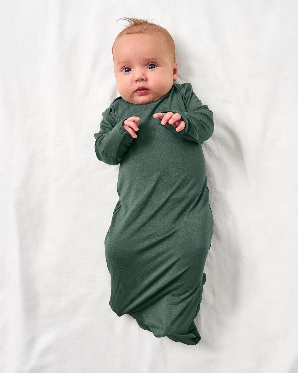 Aerial view of baby wearing the Grove Green Infant Gown
