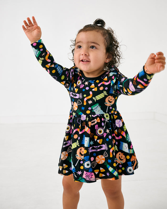 Walking toddler wearing the Halloween Haul Flutter Twirl Dress with Bodysuit