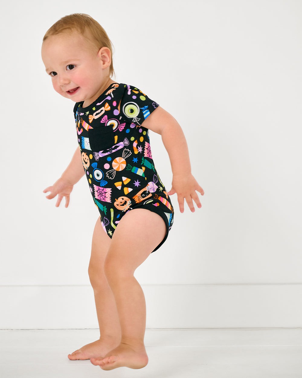 Walking toddler wearing the Halloween Haul Pocket Bodysuit