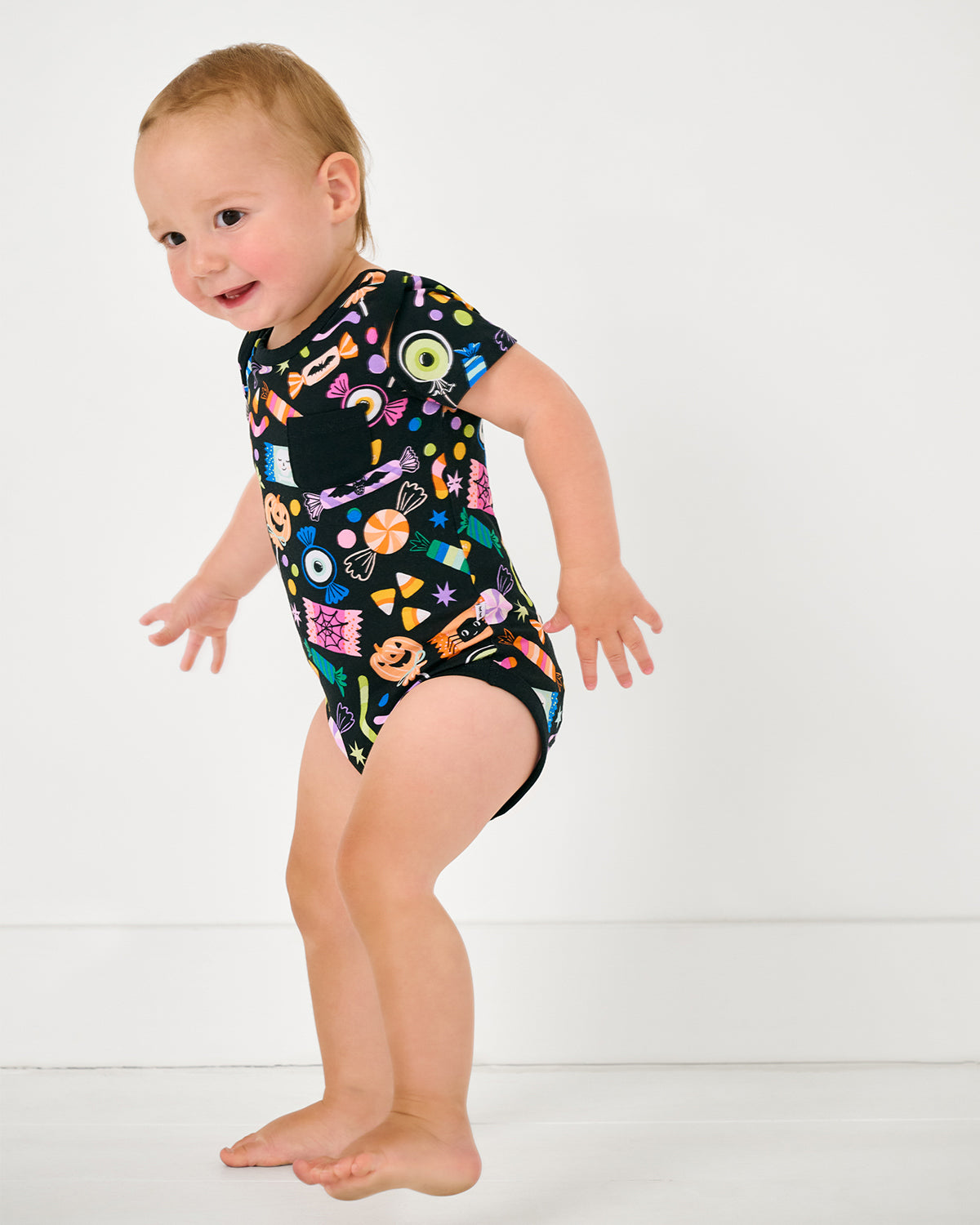 Walking toddler wearing the Halloween Haul Pocket Bodysuit