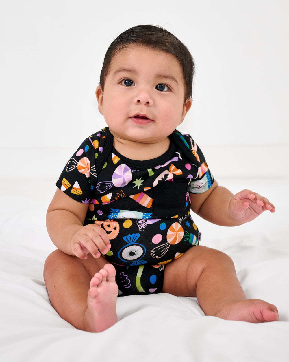 Sitting baby wearing the Halloween Haul Pocket Bodysuit