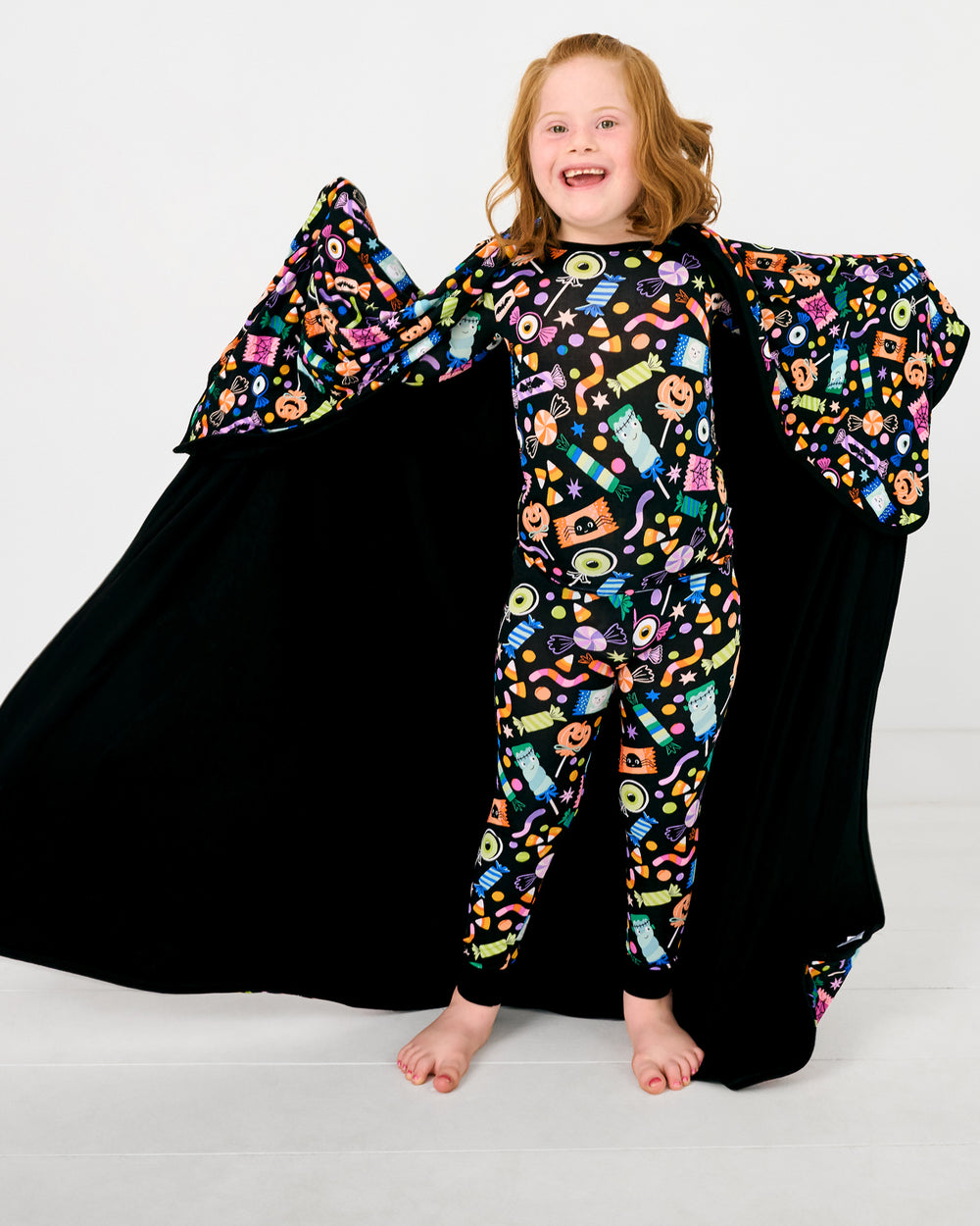 Standing child holding up the Halloween Haul Large Cloud Blanket®