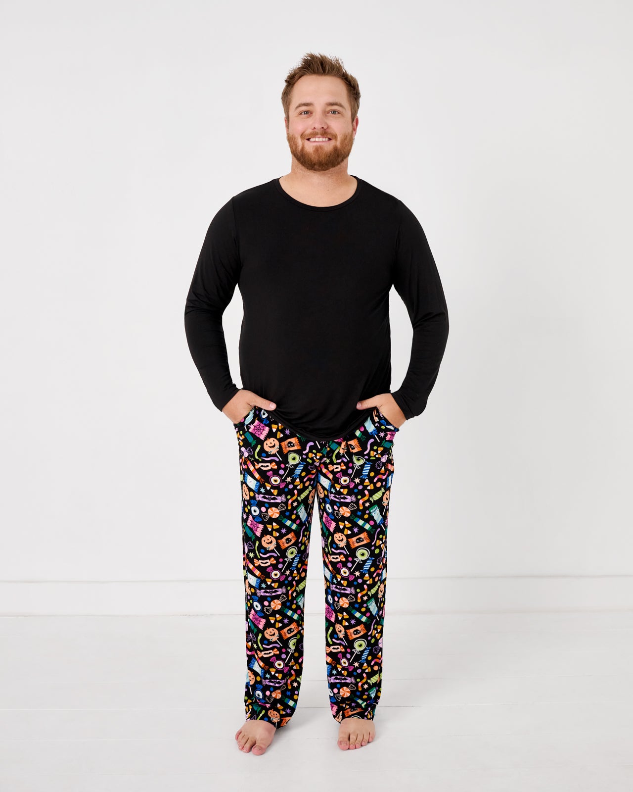 Standing man wearing the Halloween Haul Men's Pajama Pants with a black mens pajama top