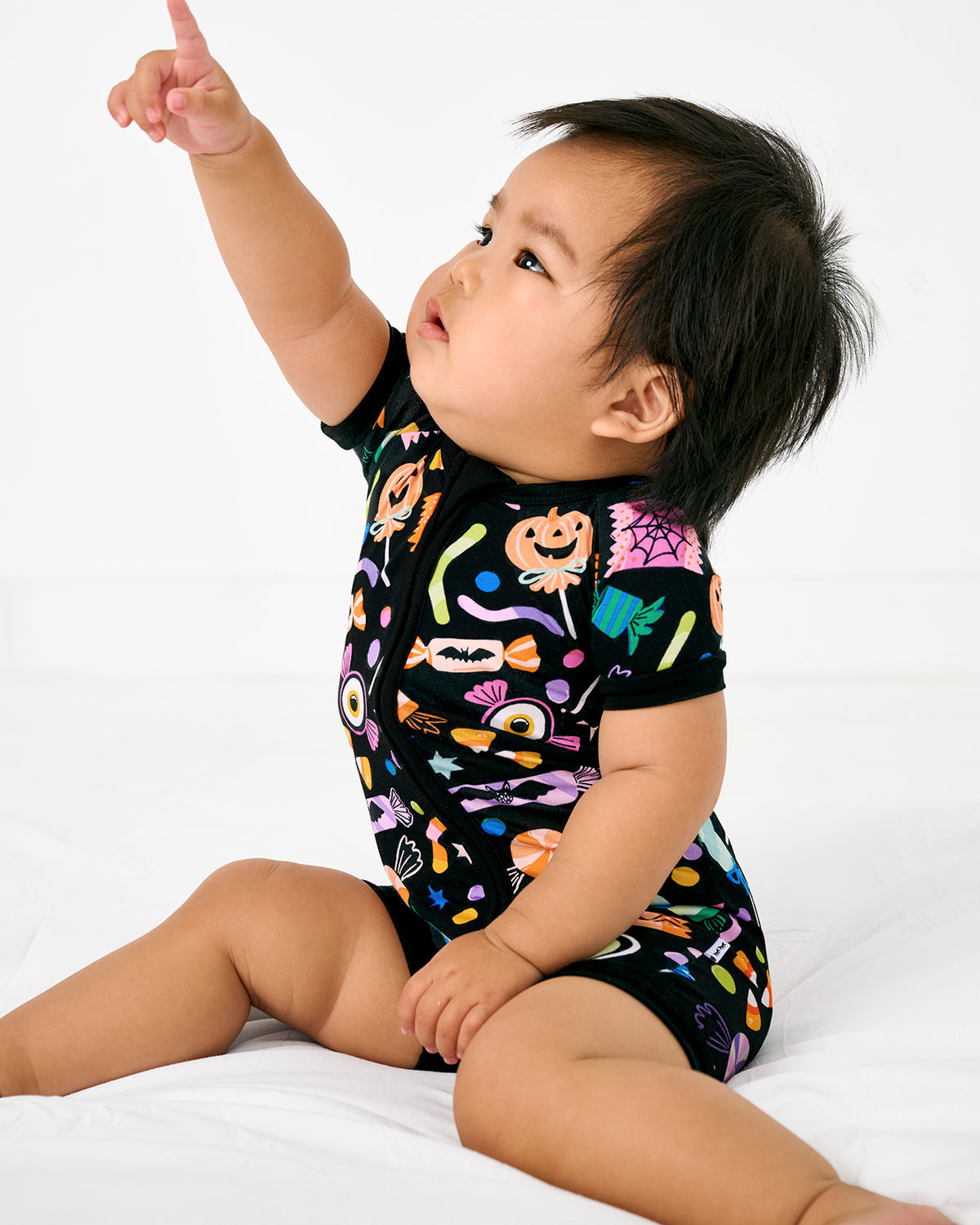 Sitting baby wearing the Halloween Haul Shorty Zippy