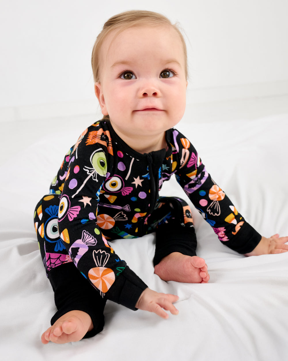 Sitting baby wearing the Halloween Haul Zippy