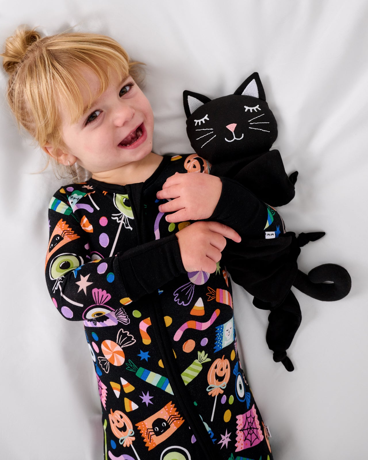 Child laying with the Midnight the Cat Sleepyhead Lovey