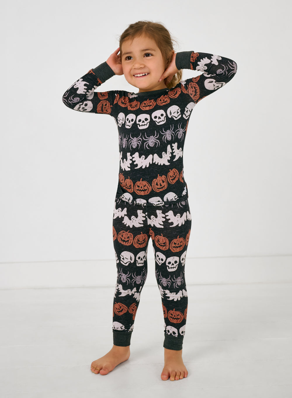 Standing child wearing the Hallows Eve Two-Piece Pajama Set