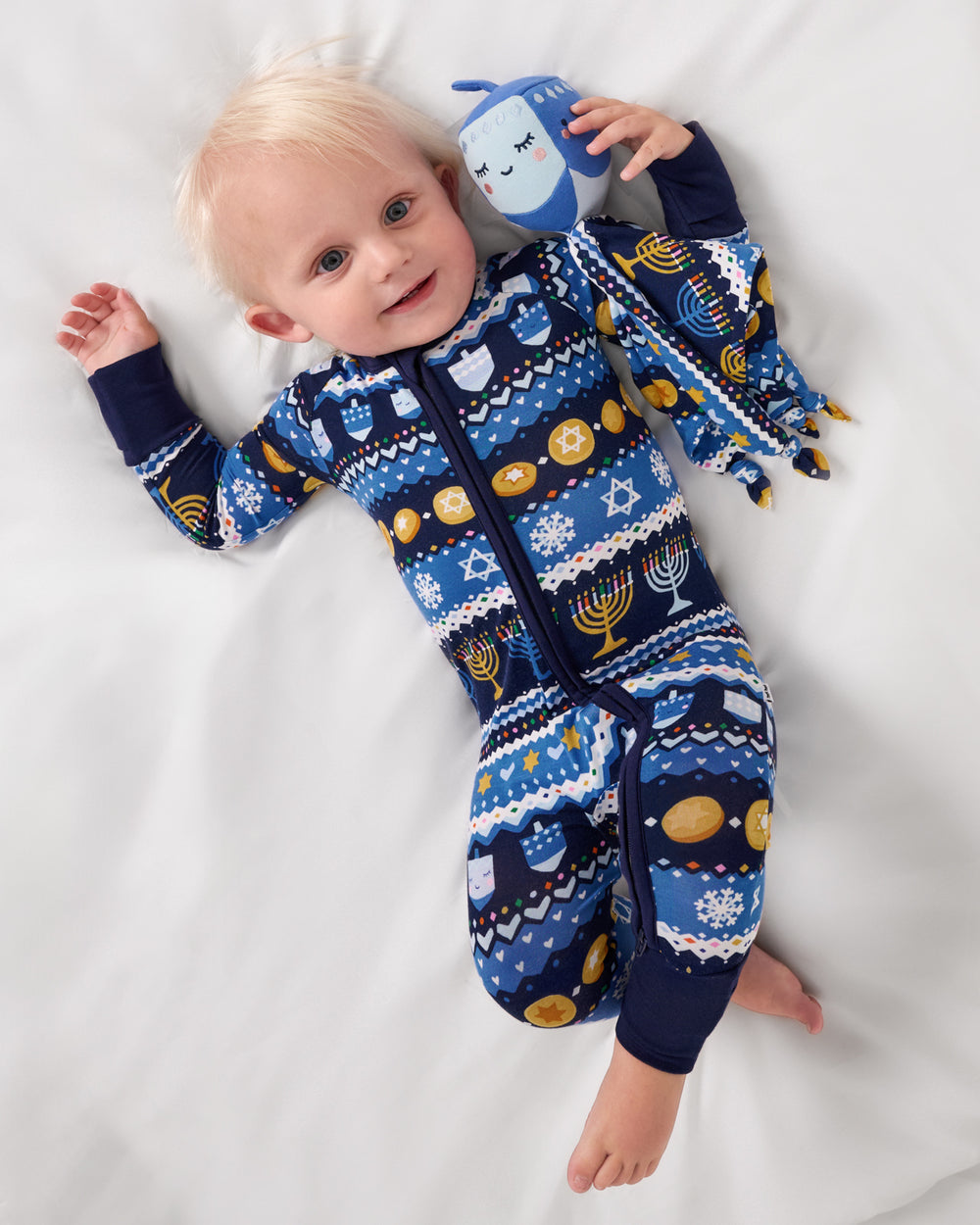 Aerial view of baby holding the Danny the Dreidel Sleepyhead Lovey