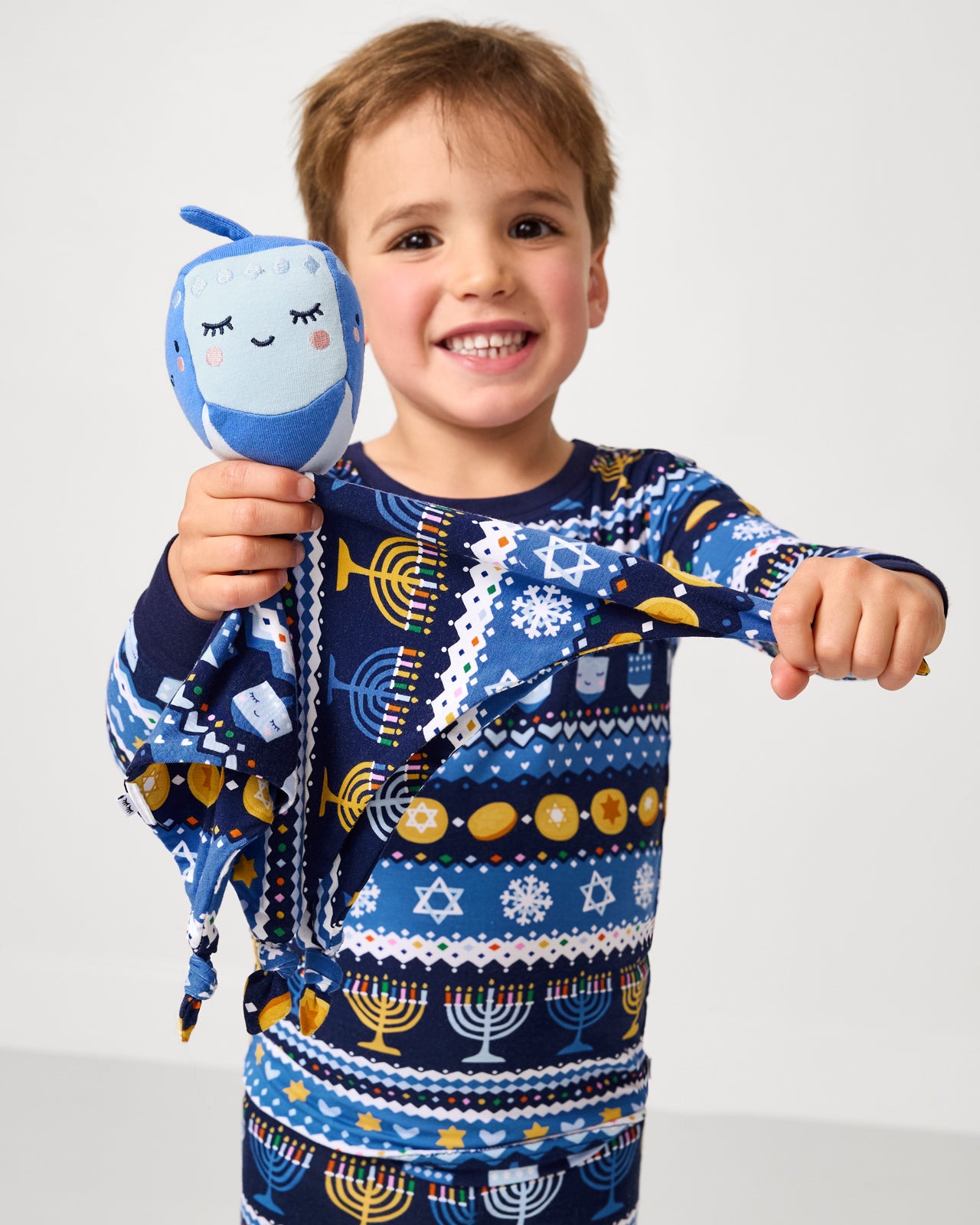 Boy holding up the Danny the Dreidel Sleepyhead Lovey