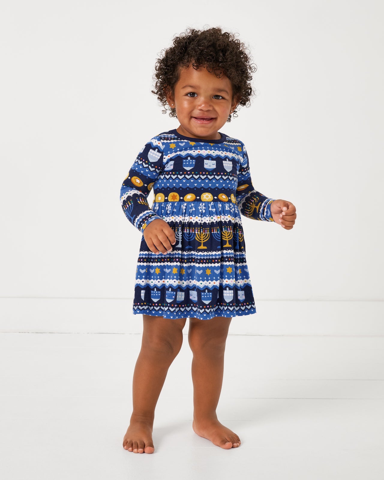 Standing girl wearing the Hanukkah Fair Isle Skater Dress with Bodysuit