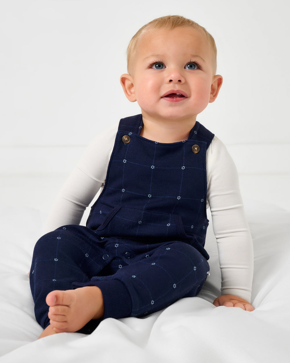 Sitting baby wearing the Hanukkah Stars Overall