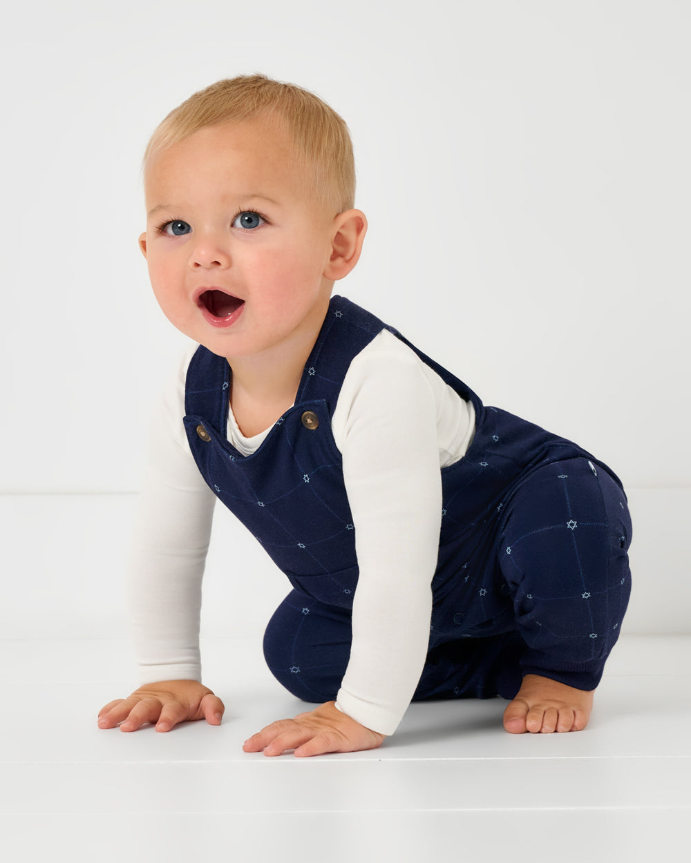 Crawling baby wearing the Hanukkah Stars Overall