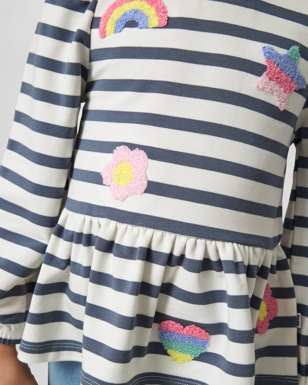 Close up of the embroidered details on the    Hazy Blue Stripe Puff Sleeve Peplum Top