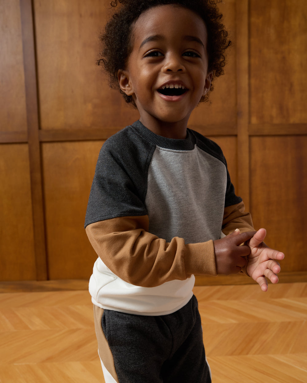 Boy wearing the Heather Gray Panel Crewneck on a wooden background