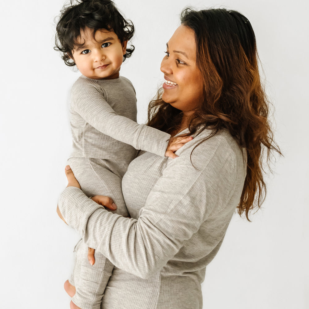 Click to see full screen - Woman holding her child wearing matching Heather Stone Ribbed pajamas. Mom is wearing a women's Heather Stone Ribbed women's pj top and child is wearing a matching crescent zippy