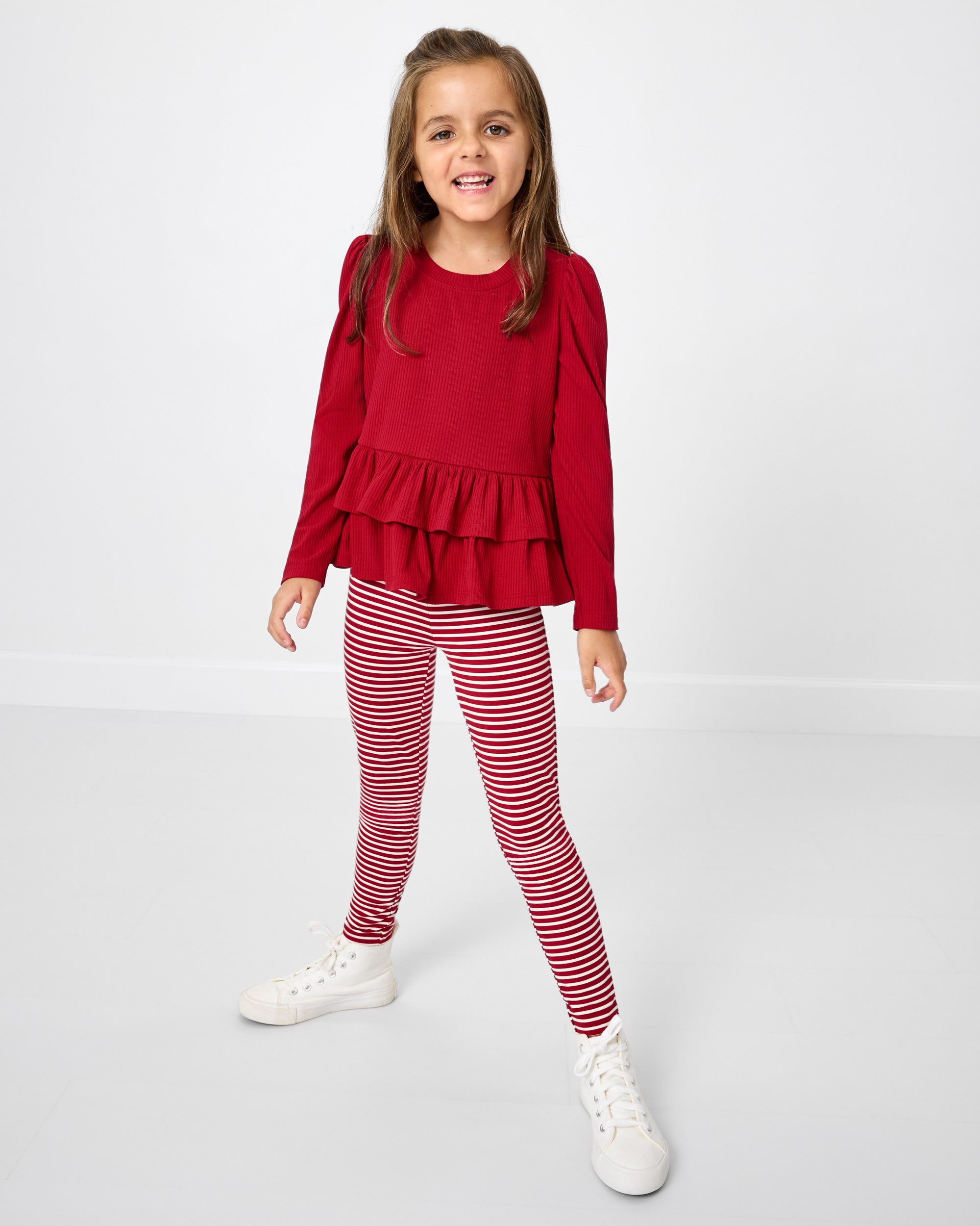 Girl wearing the Candy Cane Stripe Legging with a candy red peplum top