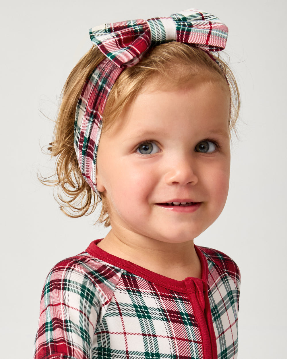 Close up of child wearing the Holly Plaid Luxe Bow Headband