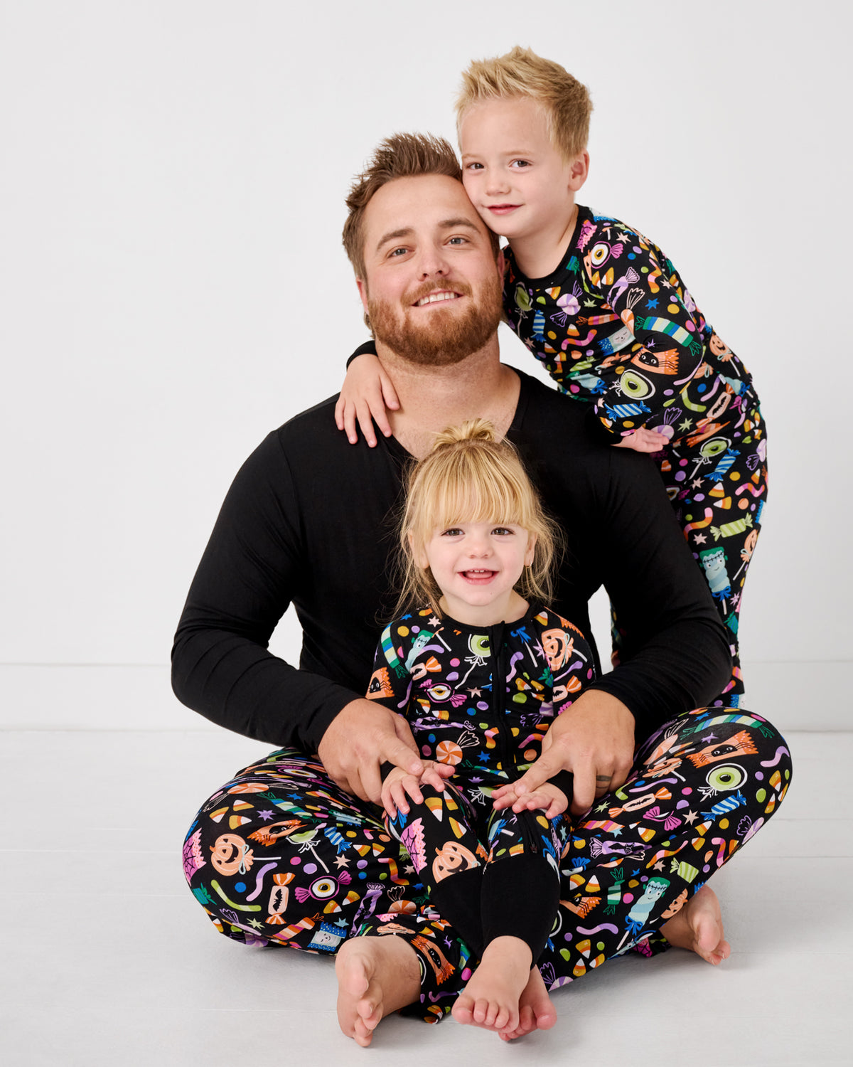 Father and two children wearing matching Halloween Haul halloween themed pajamas