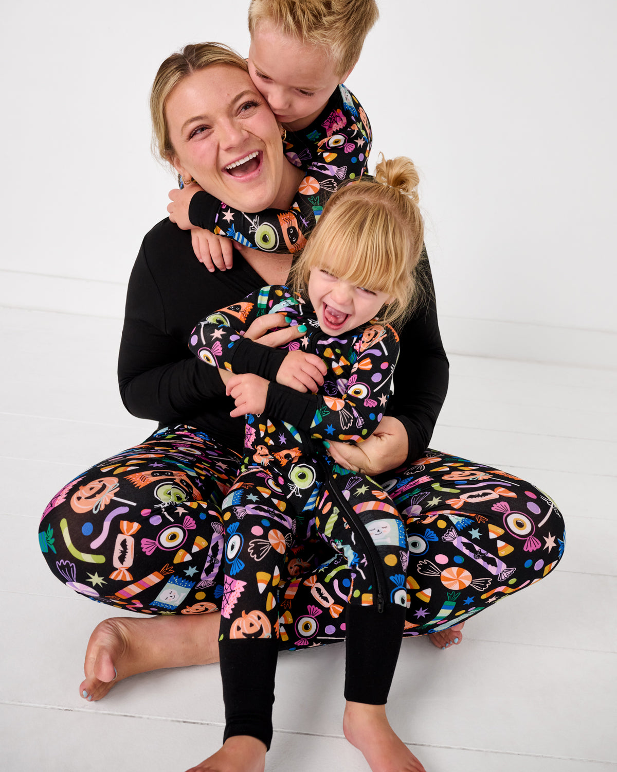 Mother and two children wearing matching Halloween Haul halloween themed pajamas