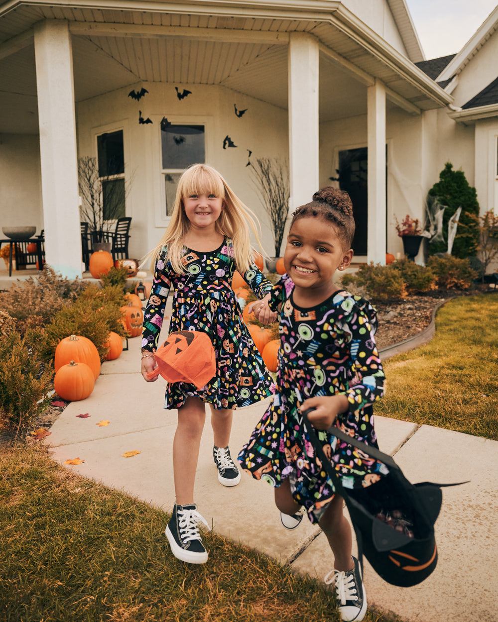 Two girls trick or treating in the Halloween Haul Flutter Twirl Dress