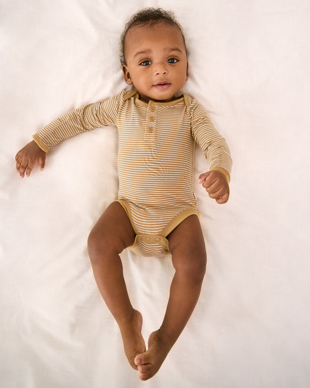 Aerial view of of baby wearing the Hazel Wood Stripe Henley Bodysuit