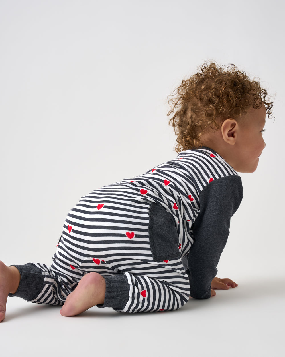 Crawling baby wearing the Heartstrings Stripe Henley Romper