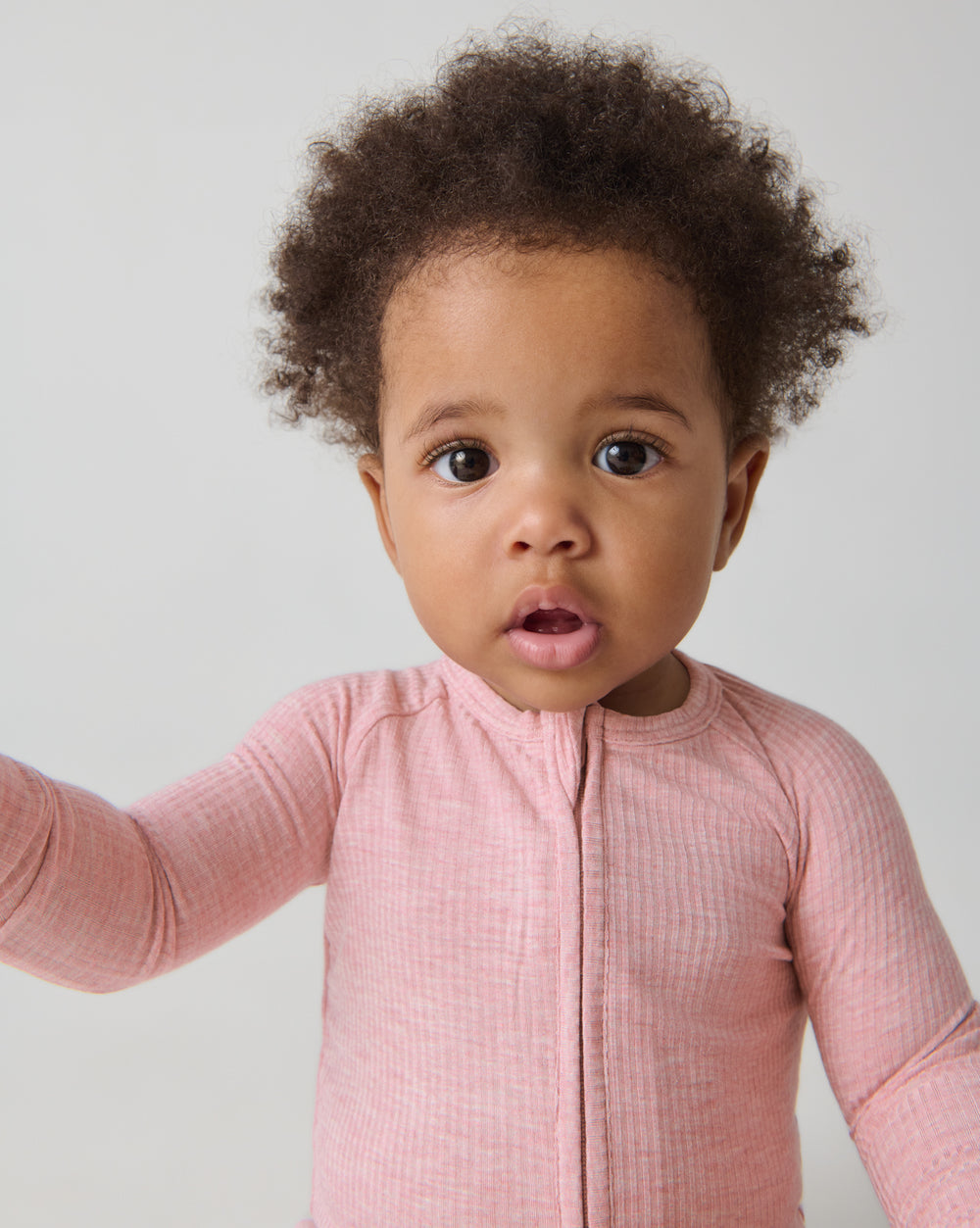 Close up of baby wearing the Heather Mauve Ribbed Zippy