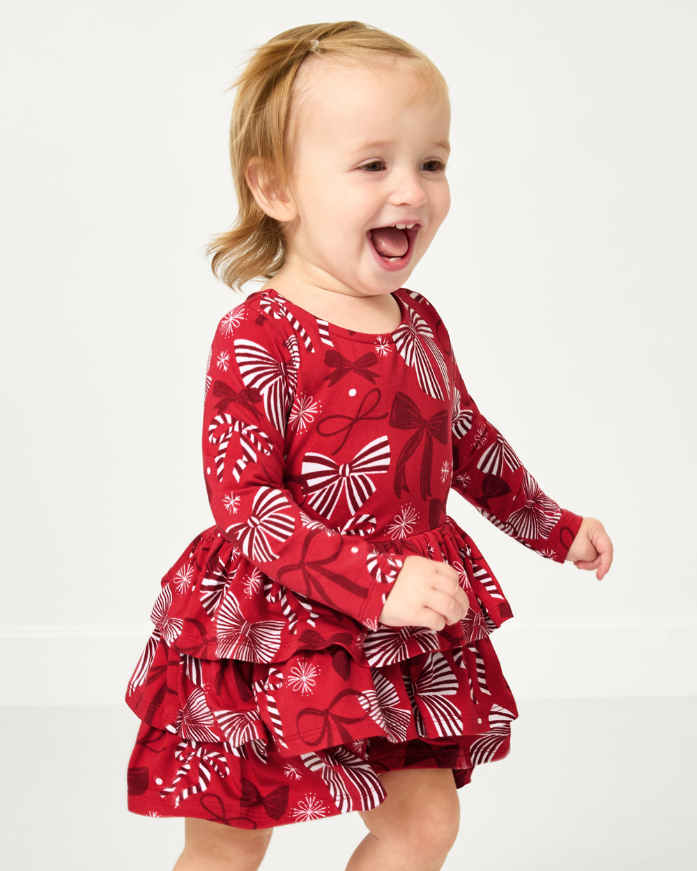 Close up of toddler wearing the Holiday Bows Tiered Dress with Bloomer