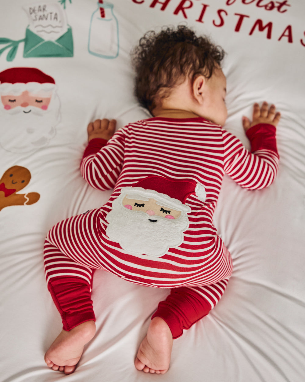 Baby wearing the Candy Cane Stripe Crescent Zippy on a festive blanket