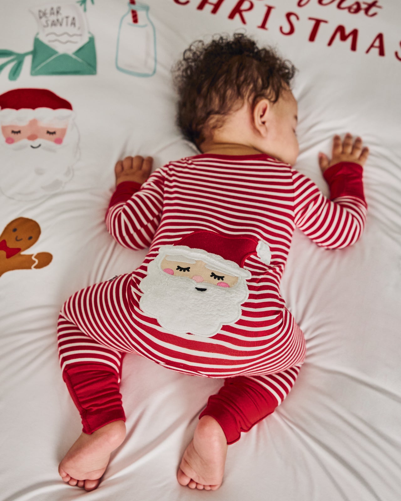 Baby wearing the Candy Cane Stripe Crescent Zippy on a festive blanket