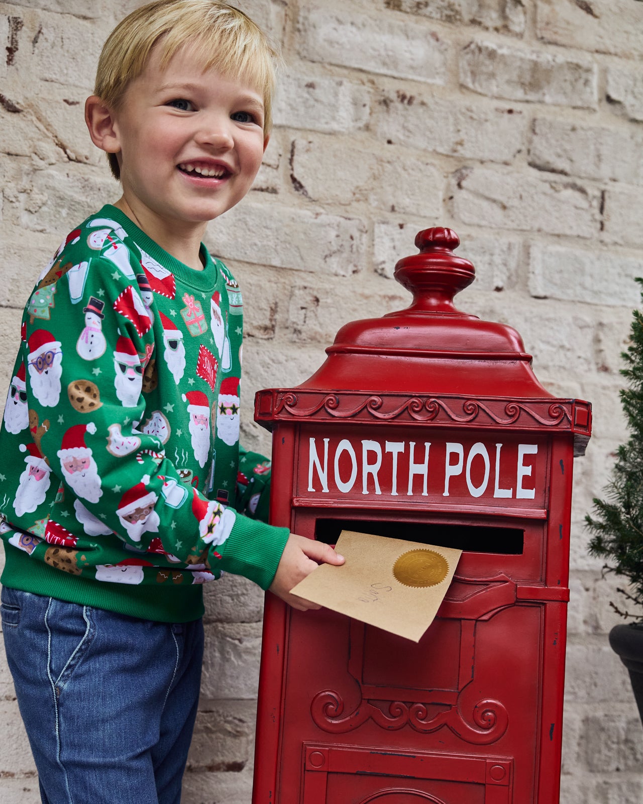 Boy wearing the Cookies for Santa Crewneck Sweatshirt sending mail to Santa