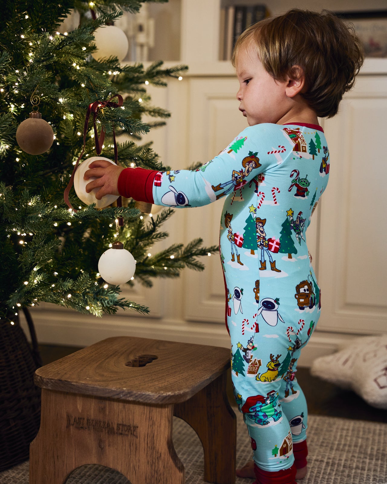 Baby wearing the Pixar Christmas Village Zippy in a festive room